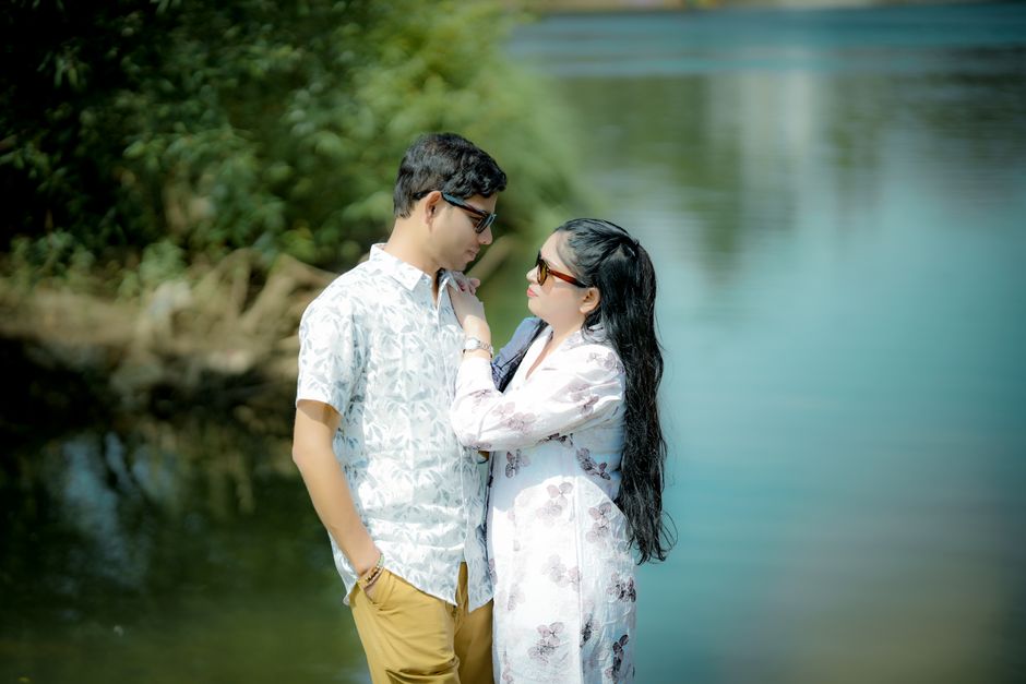 A romantic moment between a couple by the calm waters, showcasing love and connection outdoors.