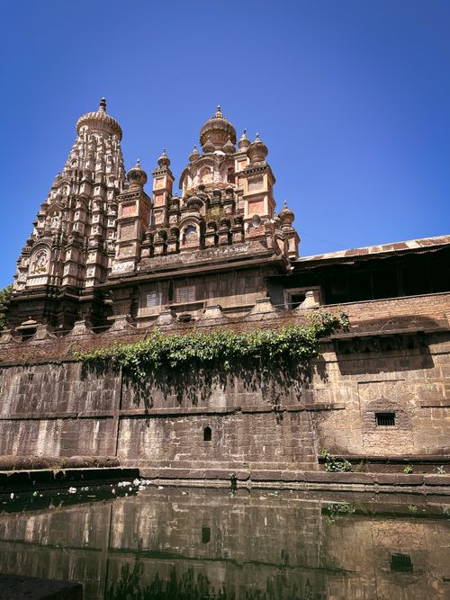 Free Majestic Indian temple with intricate architecture reflecting in a serene pool under a clear blue sky. Stock Photo