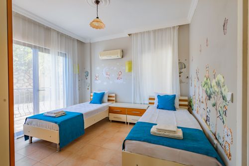 Free Comfortable twin bedroom with scenic wall art and natural light from balcony. Stock Photo
