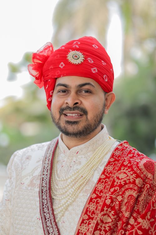 Free A portrait of an Indian groom wearing traditional red and white attire, showcasing rich cultural fashion. Stock Photo