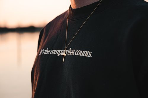 Free Close-up view of a pendant necklace and text on a shirt during a serene sunset in Venice. Stock Photo