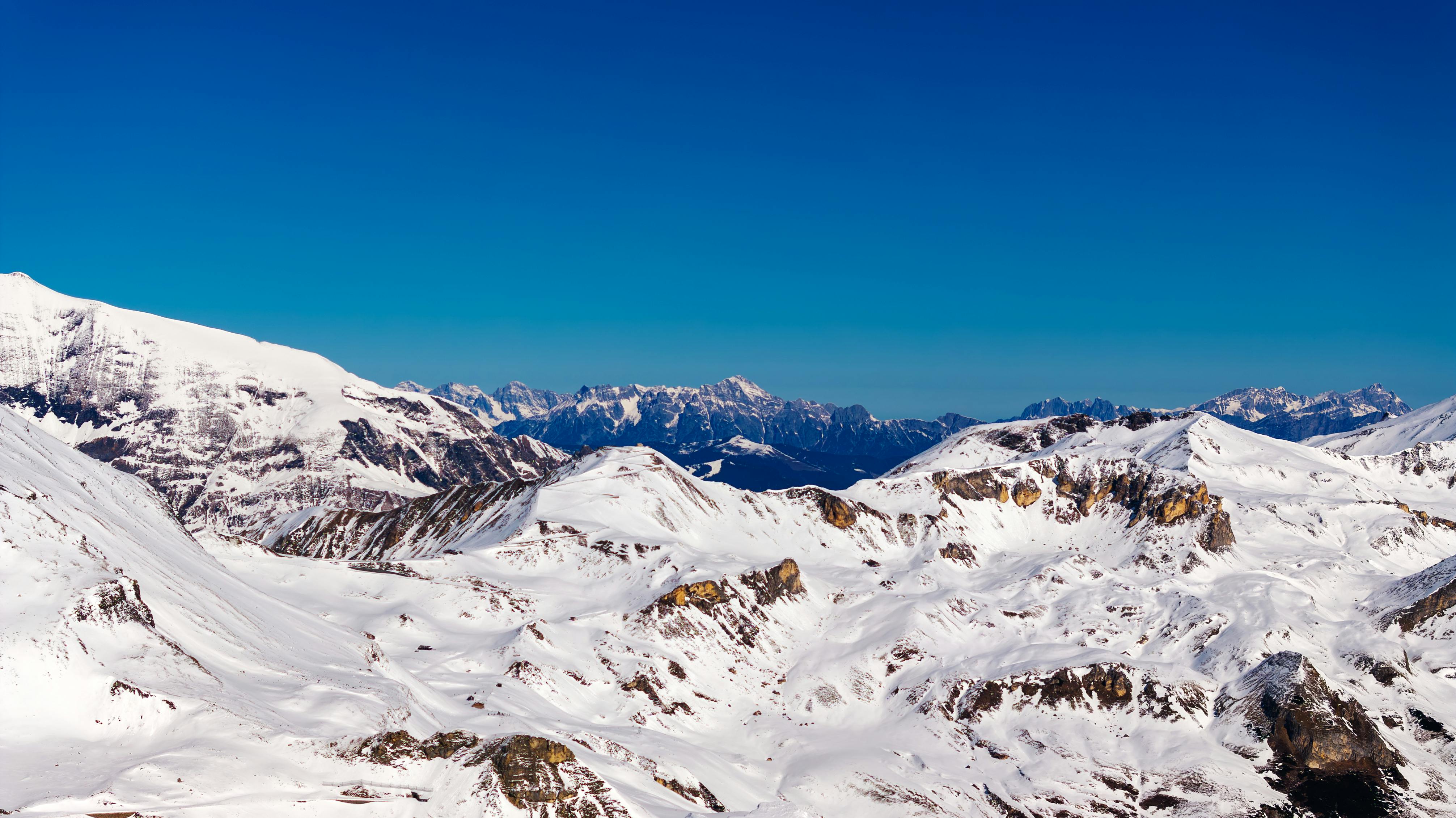 Stunning view of snow-covered mountains in Korutany, Rakousko with bright blue skies.