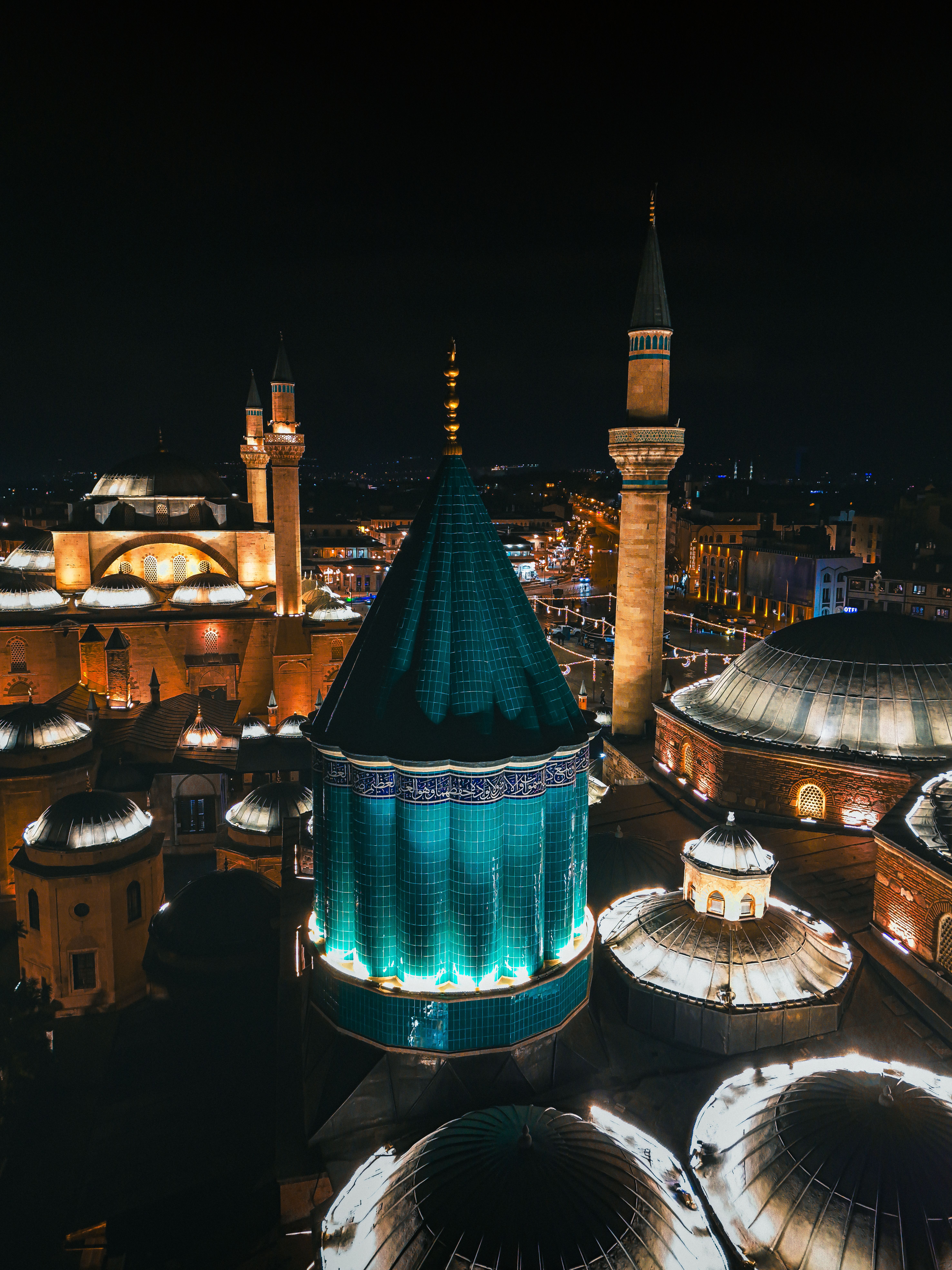 Stunning aerial view of the illuminated Mevlana Museum in Konya at night.