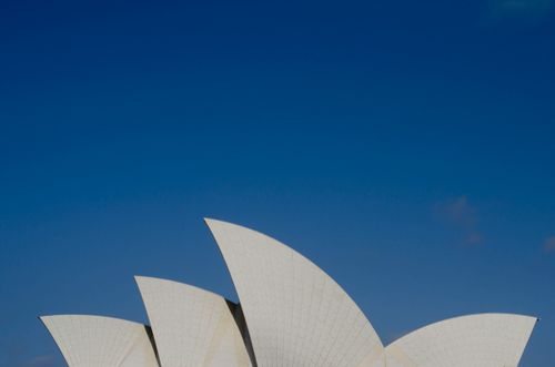 Free A stunning view of the Sydney Opera House under a clear blue sky, highlighting its architectural beauty. Stock Photo