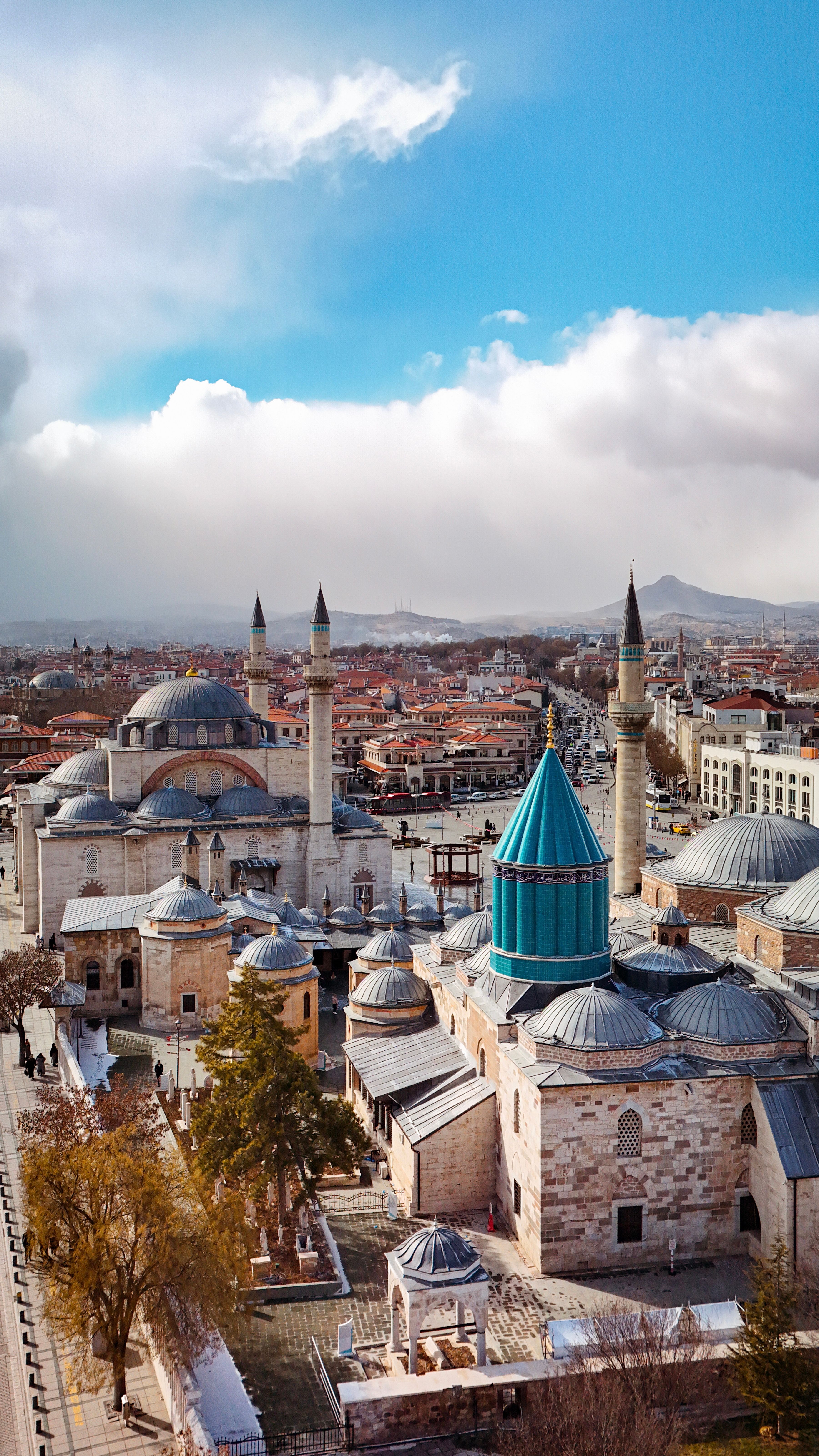 Captivating aerial view of the Mevlana Museum in Konya, Türkiye against a vibrant sky.