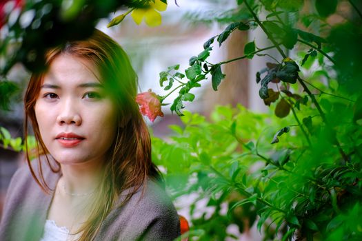 Captivating portrait of a woman surrounded by vibrant green foliage.