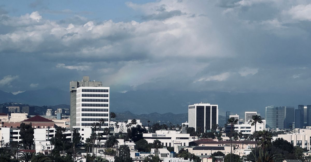 A scenic view of Santa Monica's skyline with the mountains in the background under a cloudy sky.