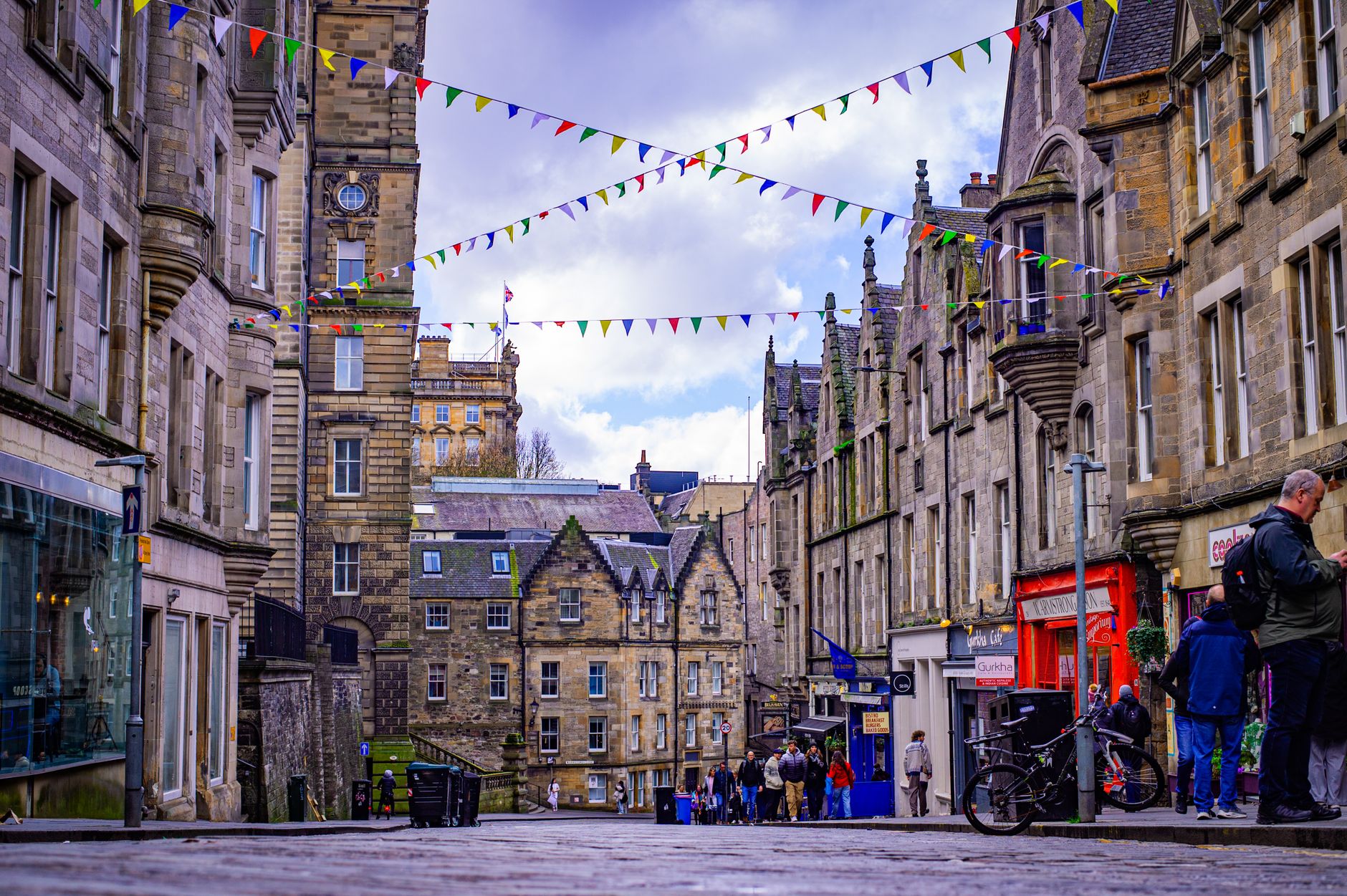Lively Edinburgh street lined with historic architecture and festive bunting