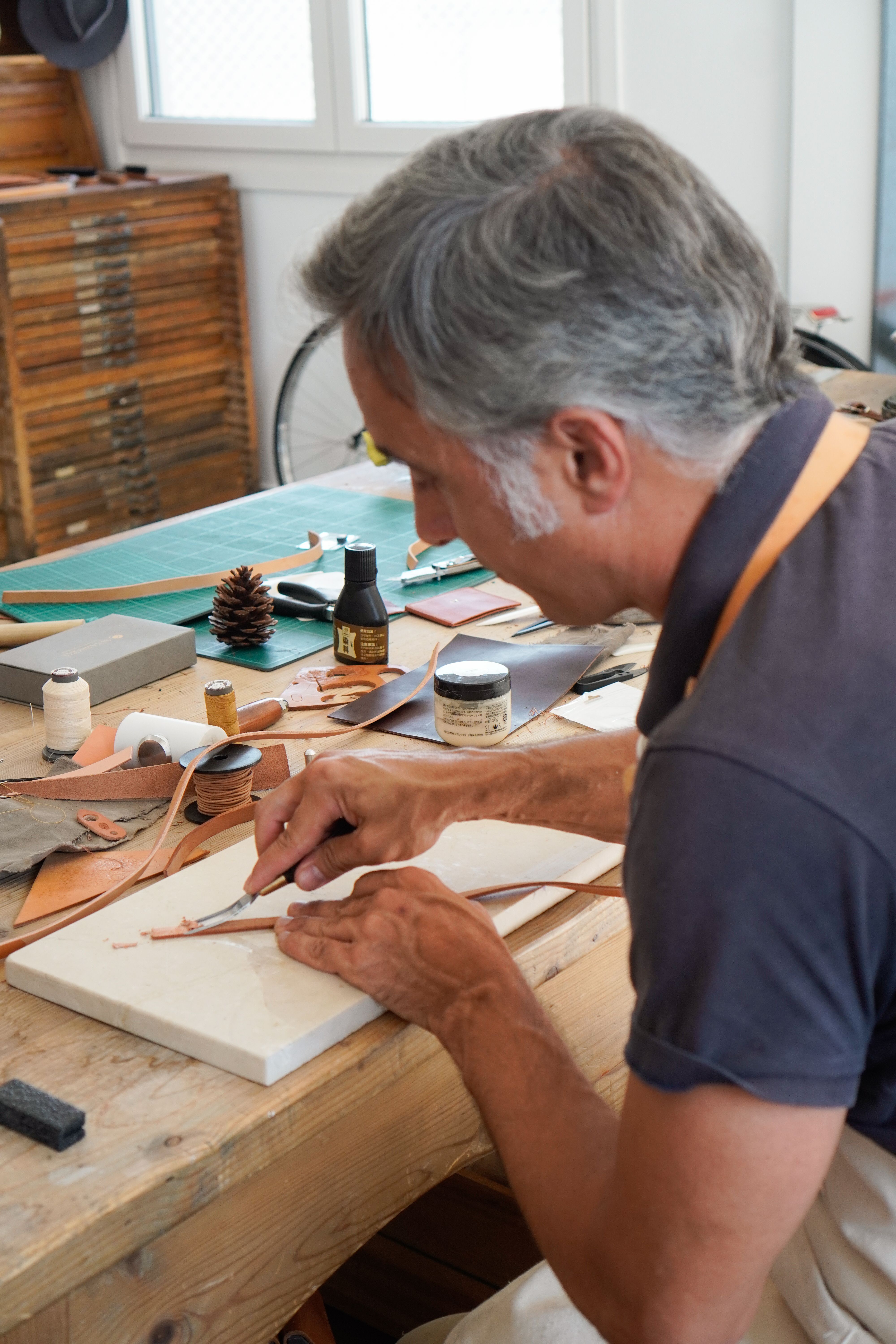 Experienced craftsman working on leather piece in Madrid workshop.