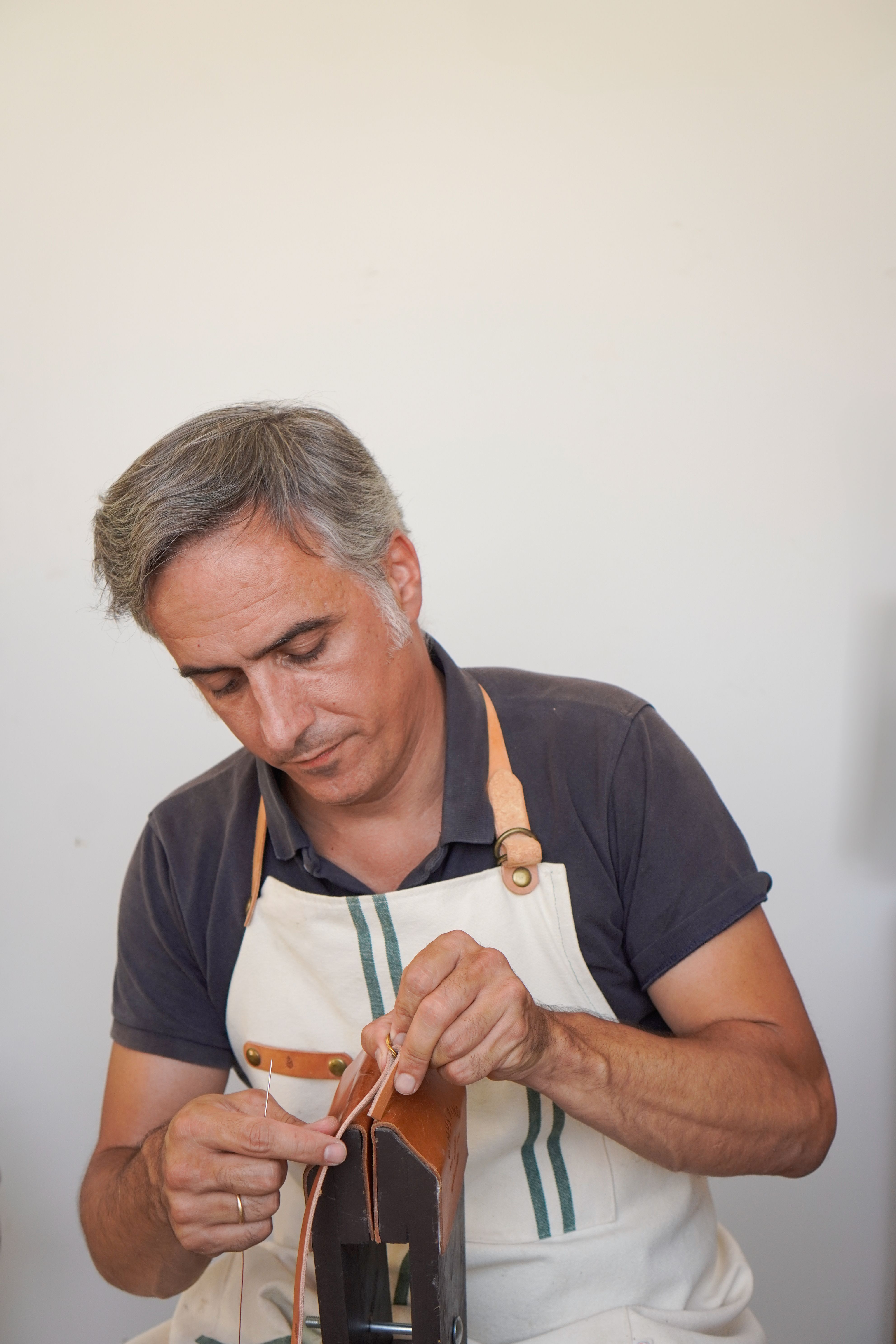 Experienced leatherworker crafting handmade product in Madrid, Spain.