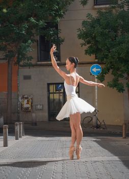 Ballet dancer performing in a sunlit street in Madrid, Spain. Artistic and elegant.