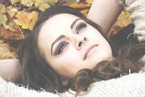 бесплатная Женщина, лежащая на засохших листьях Стоковое фото