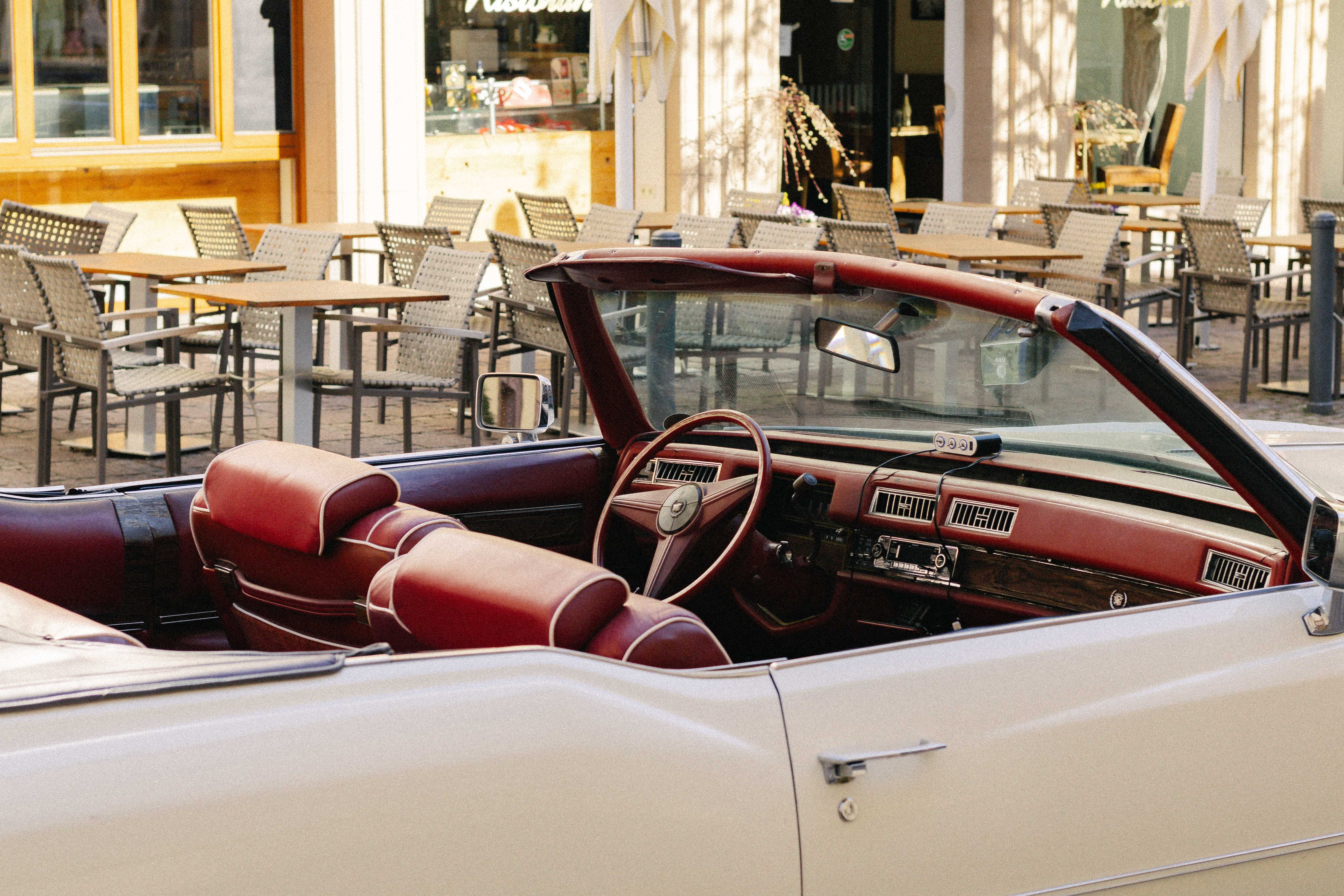 Vintage Convertible Car in Sunlit Outdoor Café Setting · Free Stock Photo