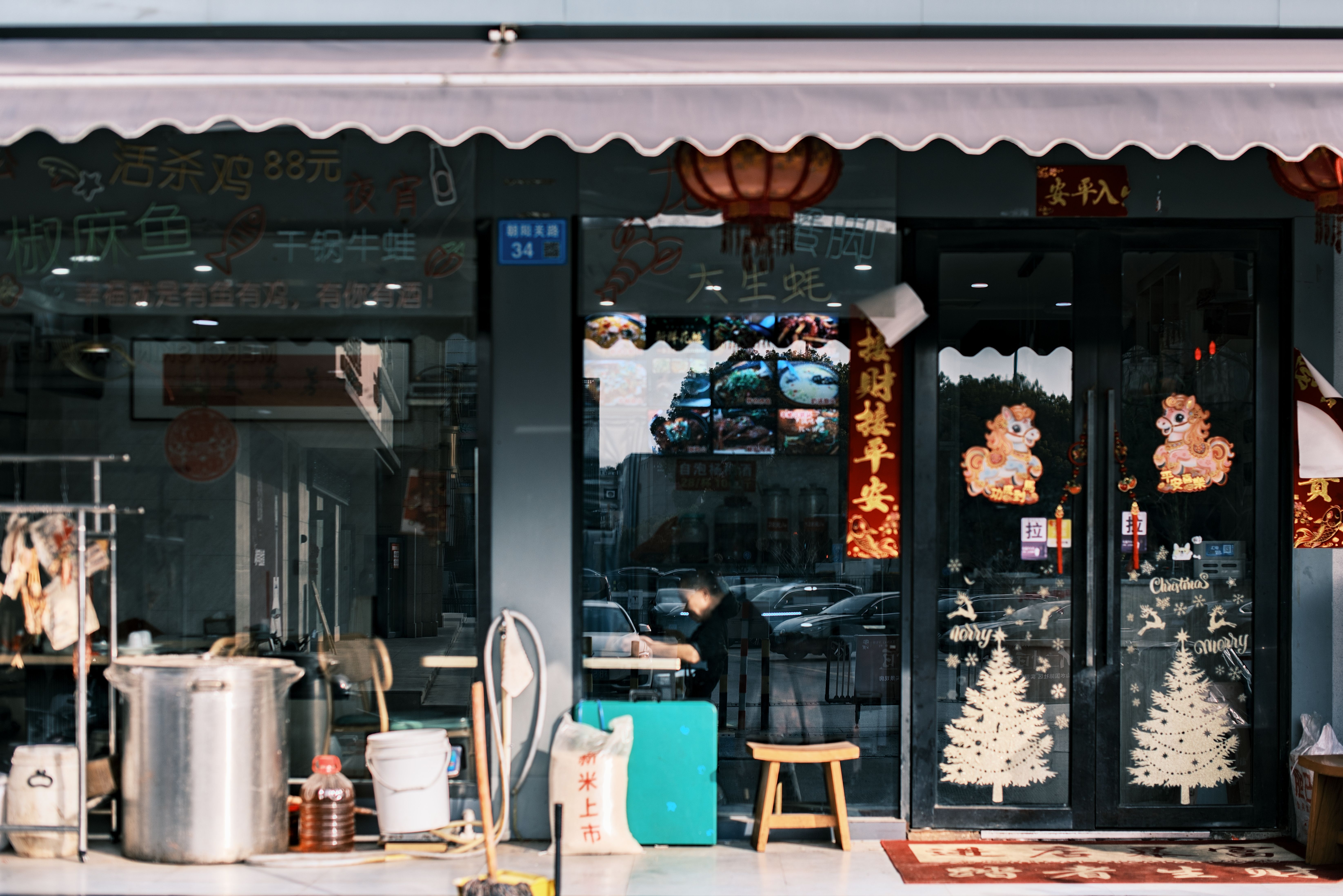 Exterior de um restaurante asiático festivo com lanternas e decorações de feriado, criando uma atmosfera acolhedora.