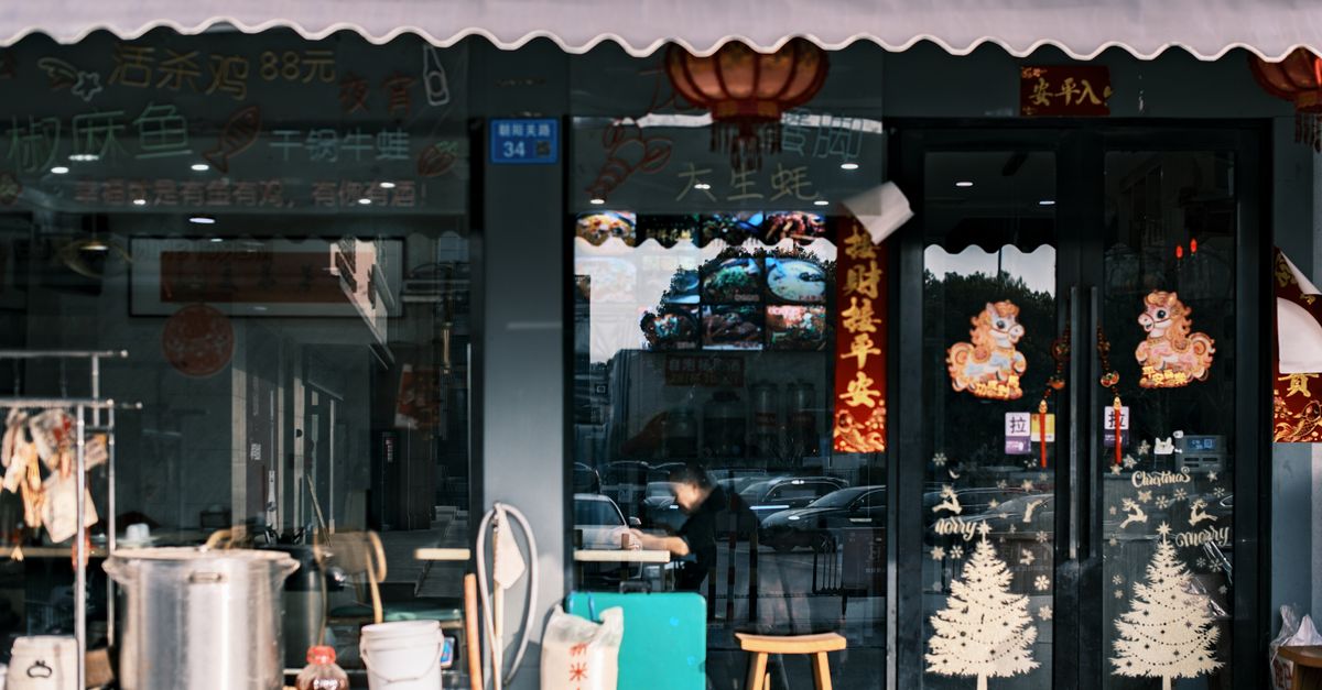 Exterior de um restaurante asiático festivo com lanternas e decorações de feriado, criando uma atmosfera acolhedora.