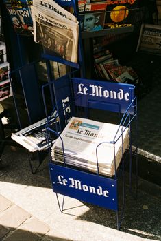 Collection of Le Monde newspapers displayed at a street newsstand in Paris, France.