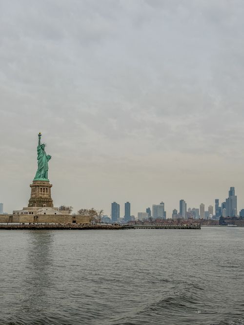 Free Iconic view of the Statue of Liberty with Manhattan skyline in the background. Stock Photo