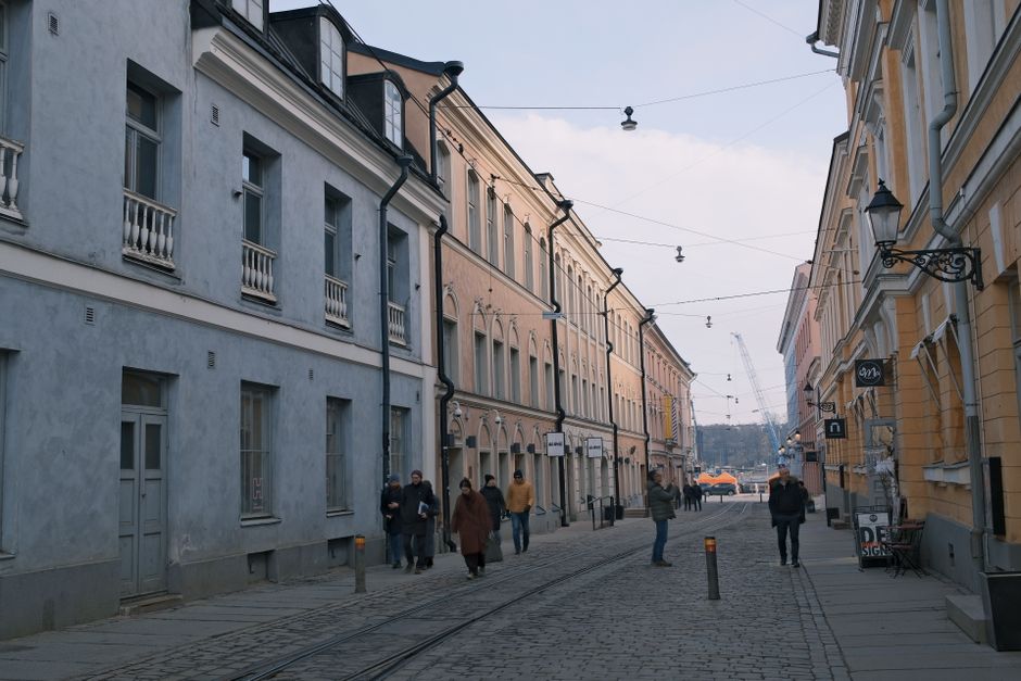 A modern HSL tram moving through a street in Helsinki, Finland.