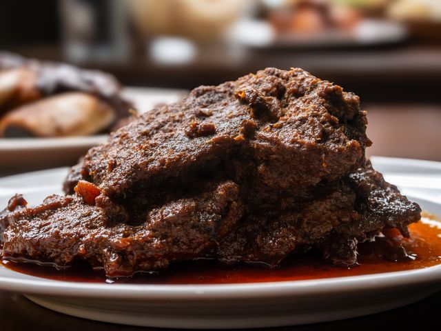 Close-up of a rich and spicy beef rendang dish, a traditional Indonesian delicacy, served on a plate.