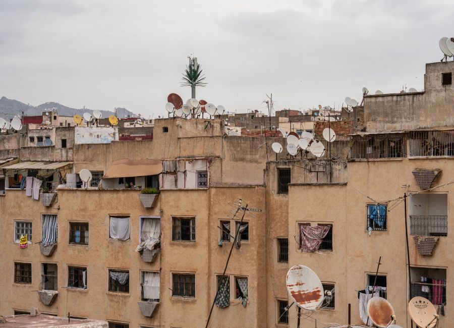 View of rooftops in Fes, Morocco, highlighting satellite dishes and urban texture.