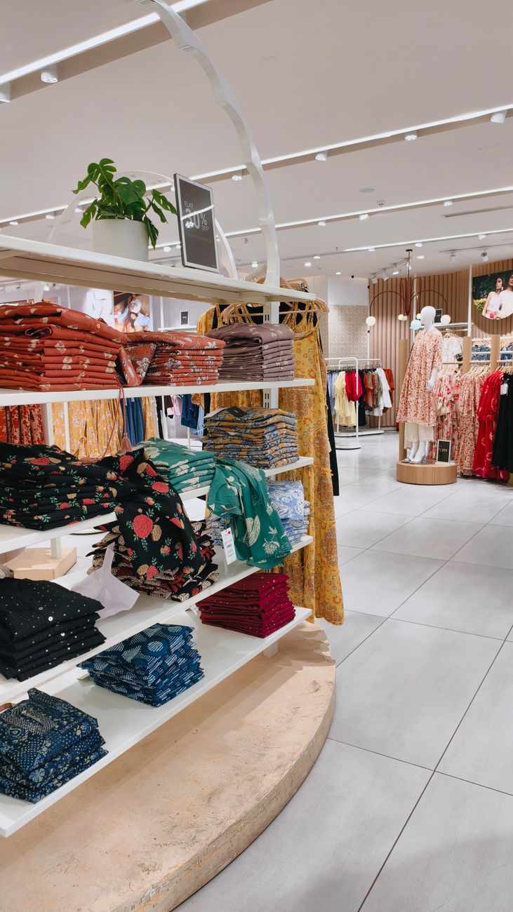 A bright and spacious fashion store interior featuring vibrant clothing displays and elegant decor.