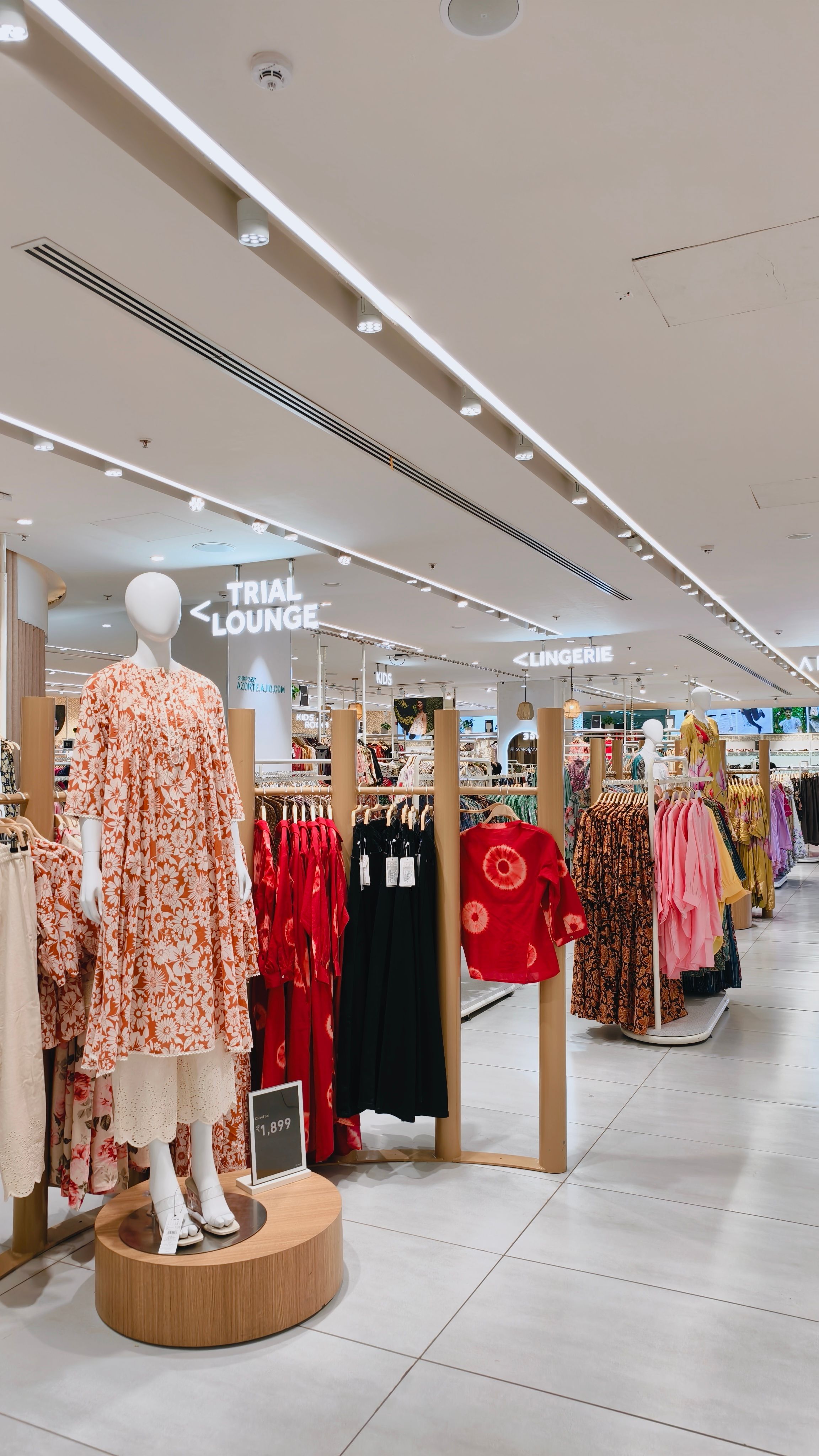 Spacious modern clothing store interior with track lighting illuminating fashion displays