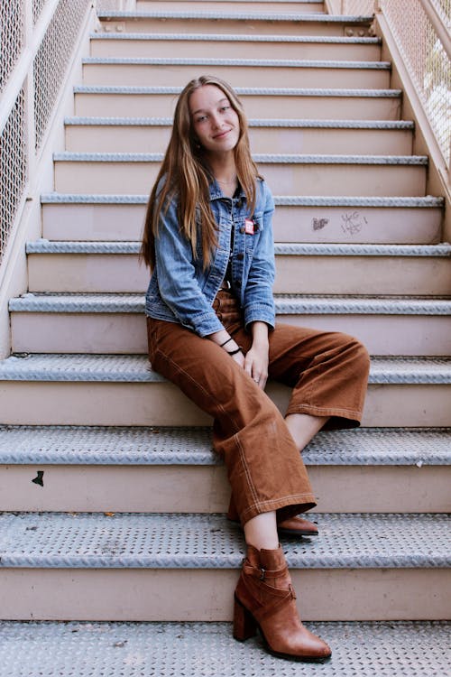 Woman in Blue Denim Jacket and Brown Pants Sitting on Stairs · Free ...
