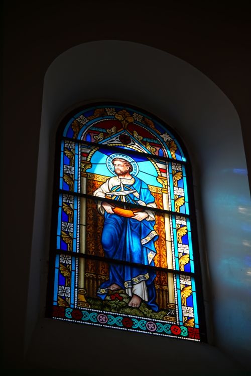 Free Vibrant stained glass window depicting a biblical figure in a historic church setting. Stock Photo