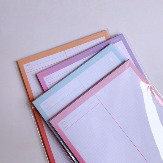 Stack of grid-paper notebooks in soft light — photo by Phuong Tran on Pexels