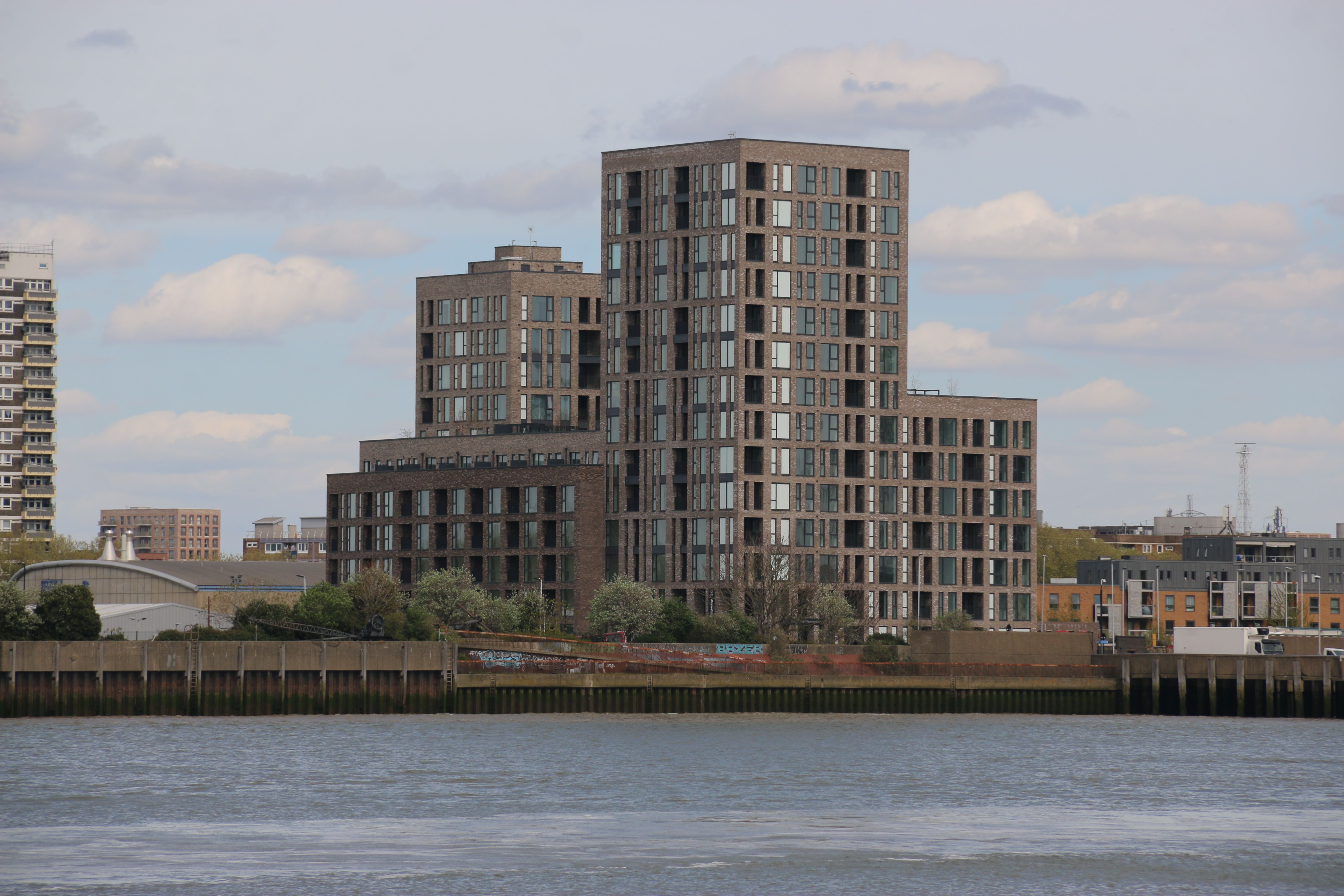 Modern Riverside Apartment Buildings on Overcast Day · Free Stock Photo