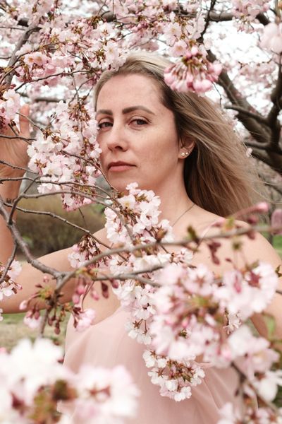 A Woman Standing and Posing under Cherry Blossom Tree · Free Stock Photo