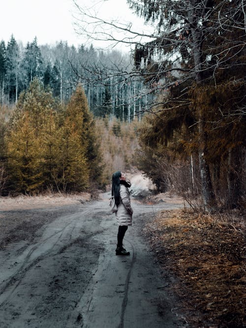 Woman Standing On The Road Looking At The Trees