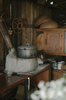 A rustic cabin kitchen featuring a vintage metal cooking pot on a traditional stove, surrounded by wooden cabinets.