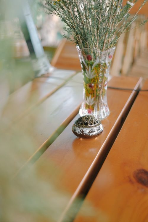 Free A decorative floral vase with dried flowers on a wooden table, perfect for rustic decor settings. Stock Photo