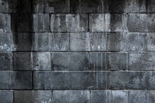 Free Close-up of a grungy concrete block wall with a weathered texture, ideal for backgrounds. Stock Photo
