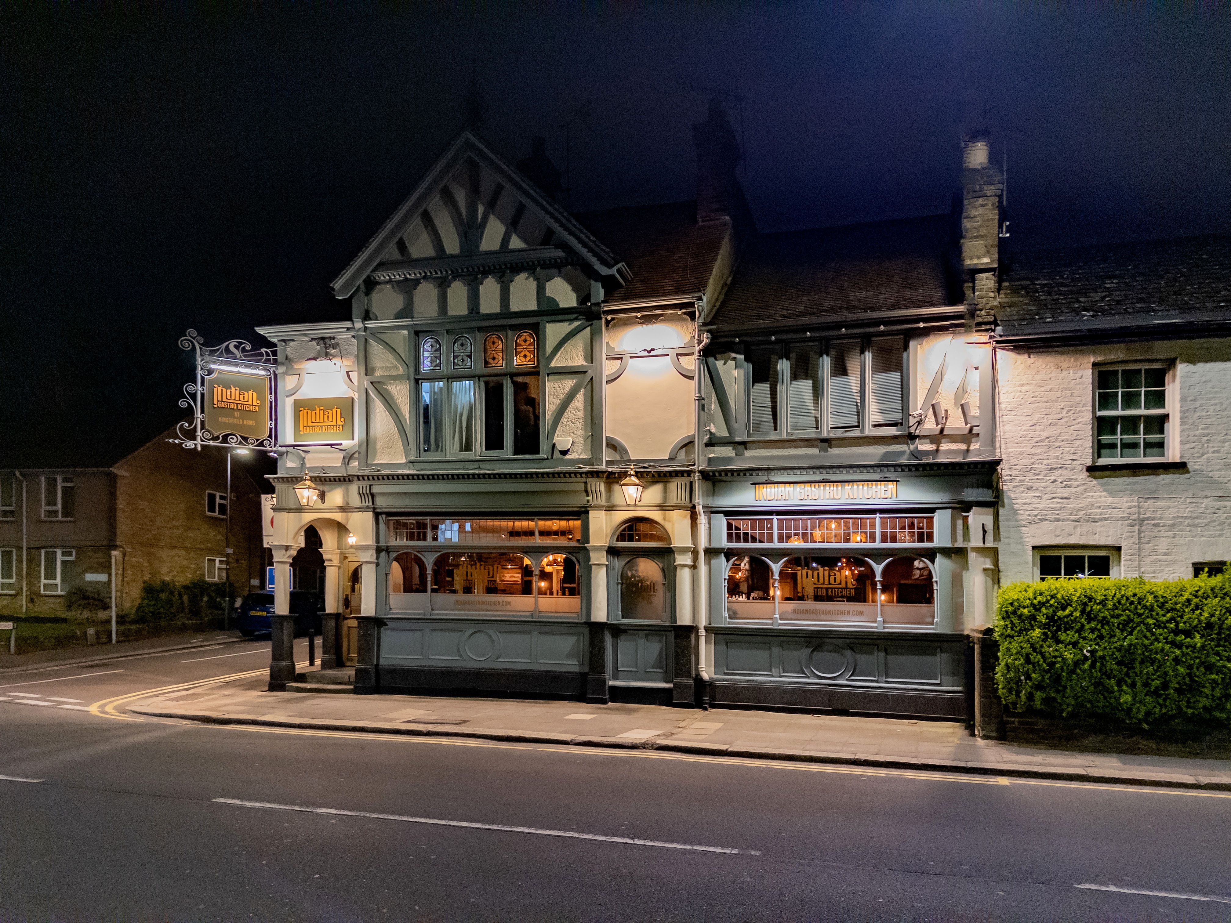 Illuminated traditional English pub in Harrow at night, showcasing classic architecture.
