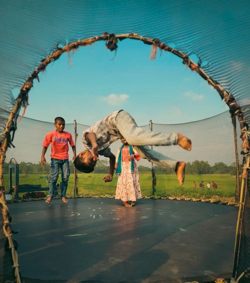 Free Children having fun on a trampoline in a rural setting during daytime. Stock Photo