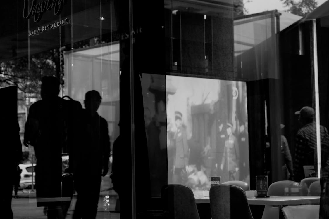 Silhouette Of People Standing Outside A Restaurant