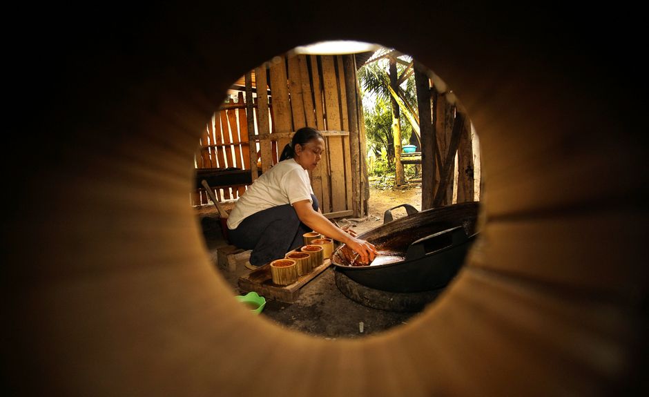 Woman making traditional brown sugar in an Indonesian kitchen.