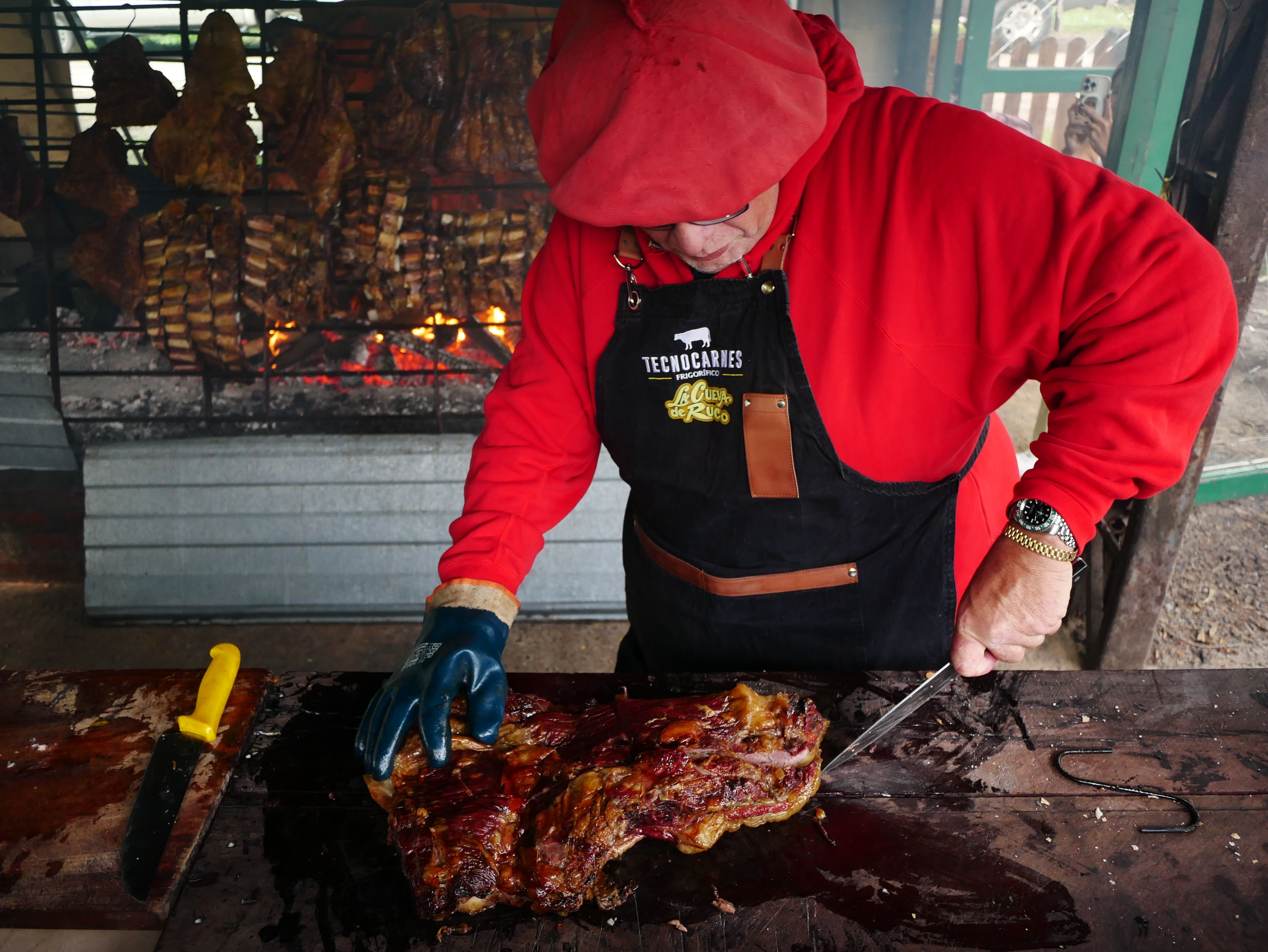 Man grilling traditional Argentine asado in Uribelarrea, Buenos Aires, showcasing local barbecue style.