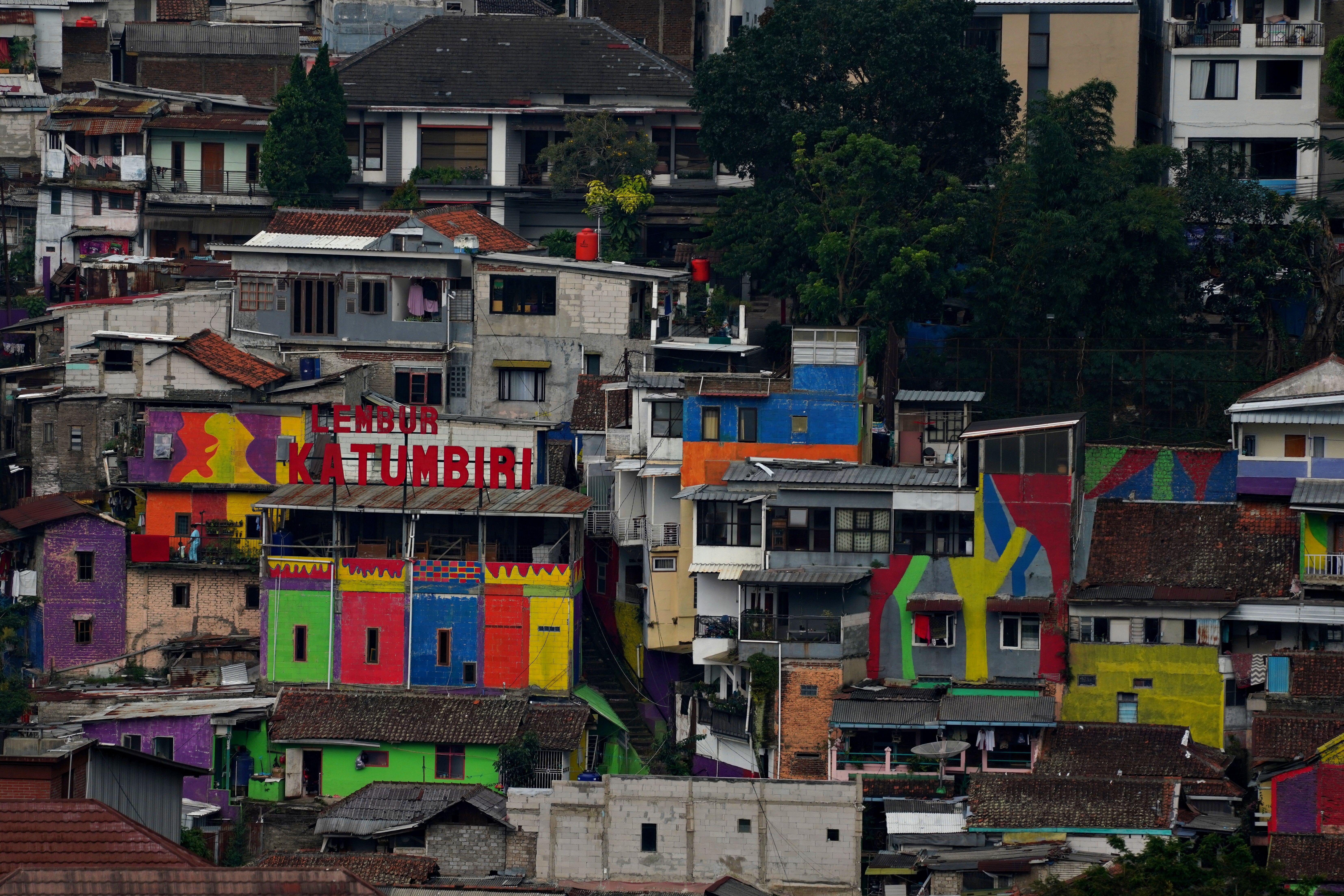 Vibrant painted buildings in a densely packed Indonesian neighborhood.