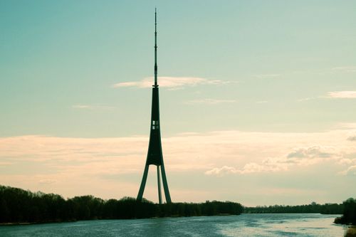 Free Majestic tower rising above the river with a backdrop of clear blue skies. Stock Photo