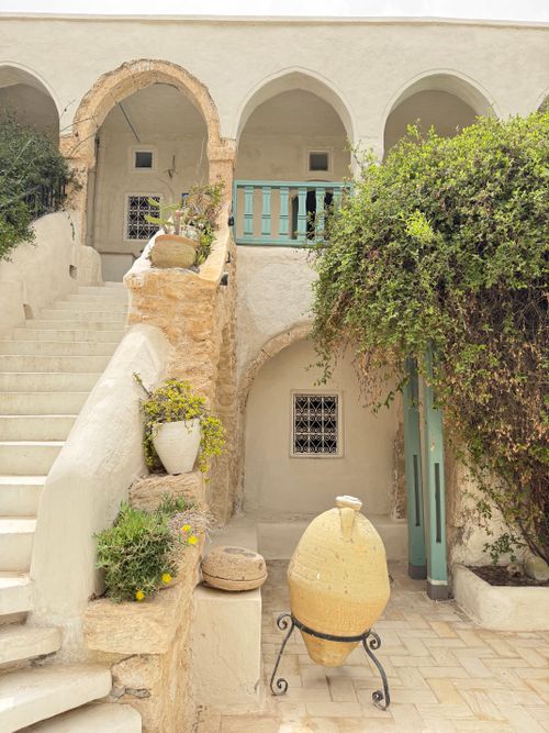 Free Traditional Tunisian architecture with arches and greenery in Houmt Souk, Tunisia. Stock Photo