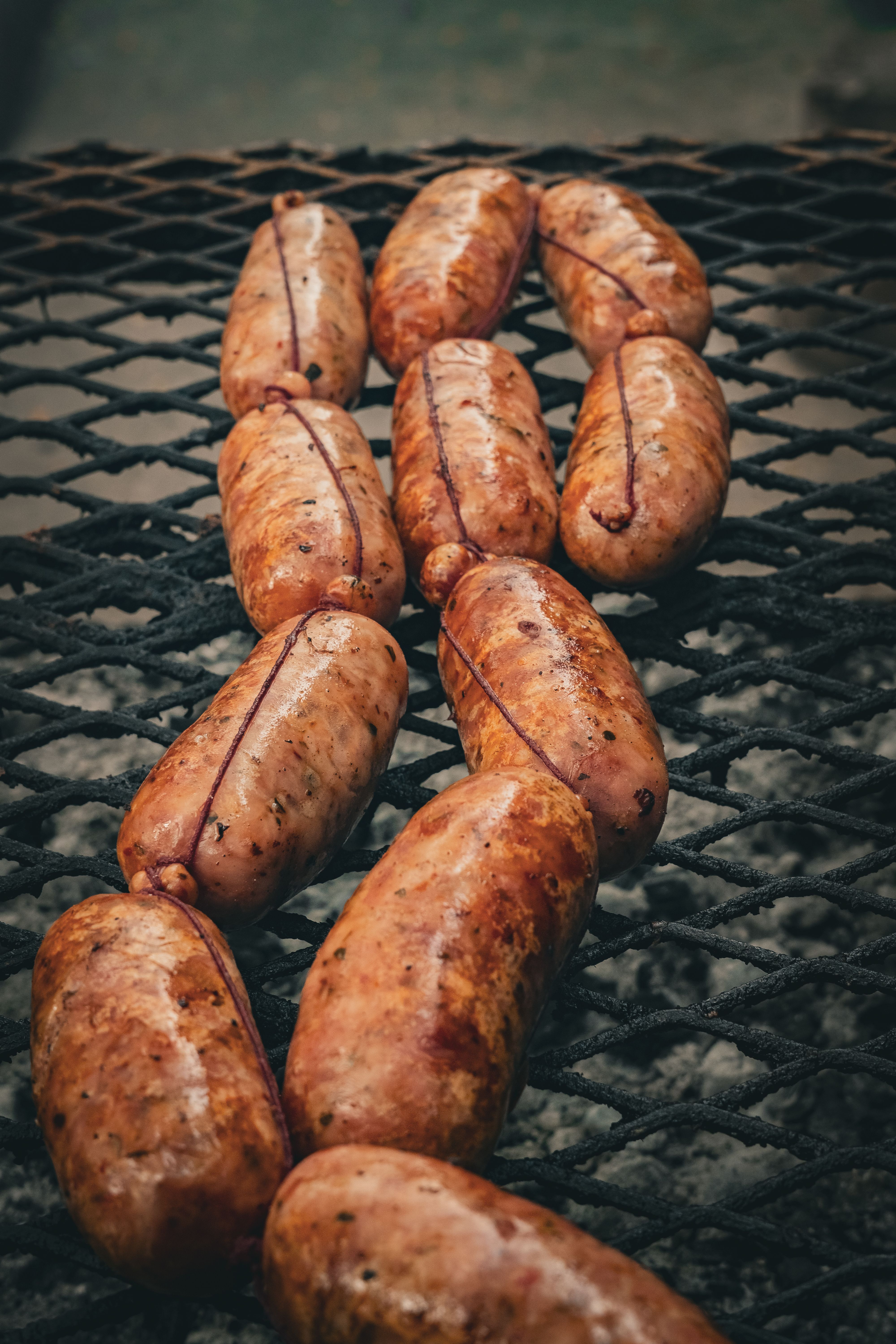 Cured Spanish chorizo sausage sliced into thin rounds, showing the deep red paprika-cured interior and marbled fat, next to a whole uncut link tied with string.