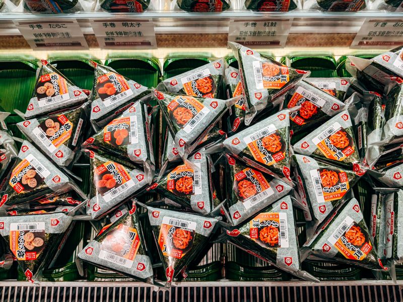 Packaged onigiri rice balls on a Japanese convenience store shelf, ready to eat