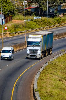 Aerial view of a highway in Eswatini showcasing a truck and van in motion on a sunny day.