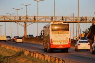 Highway traffic scene with vehicles and a pedestrian bridge at sunset in Eswatini.