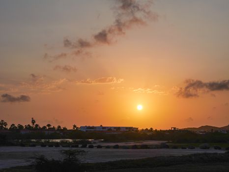 A beautiful sunset over a tropical horizon with soft clouds.