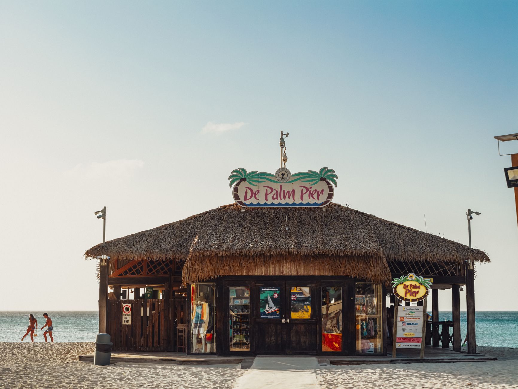 Beach hut at De Palm Pier in Aruba with clear skies and sparkling ocean.