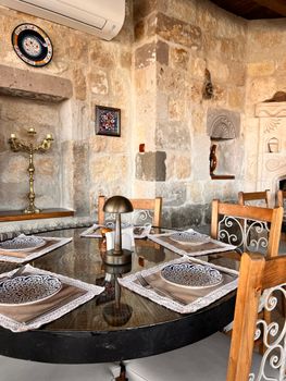 Cozy dining area with stone walls and elegant table setting in a rustic indoor space.